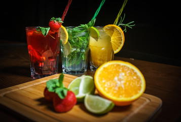 Fresh cocktail on a black background. Alcoholic cocktail on a black background. Fruit with a cocktail. Non-alcoholic cocktail. Mix of cocktails on a black background. 