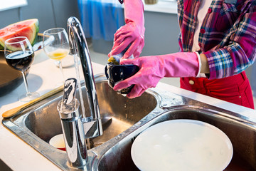 Woman washes dishes in kitchen