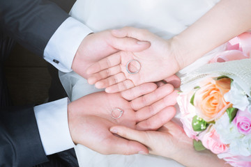 Loving Young love married couple holding hand and a ring together in ceremony wedding day marry scene propose. couple be hand in hand  promise or  swear. Shake hand with rose flower bouquet.