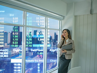 Modern business women use mobilephone talk about stock market white looking out of the window