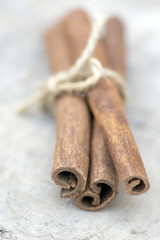 Fresh raw cinnamon sticks on wooden table, sticks tied with one jute natural twines