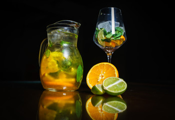 Tea on a black background. Fruit tea. Cold tea. Teapot with tea.