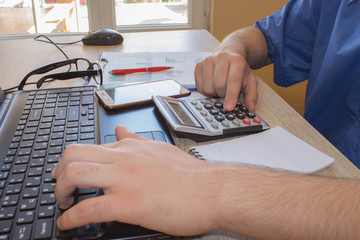 Businessman hand using calculator, accounting concept. Man hands with pencil, papers and Calculator on wooden table. Success, motivation, financial flows