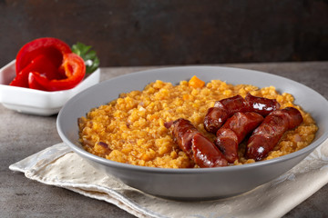 Lentils stew with fried pork sausages, onion and garlic