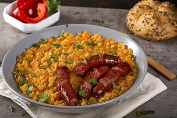 Lentils stew with fried pork sausages, onion and garlic