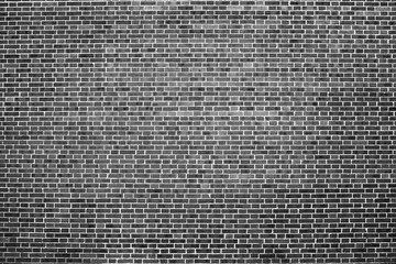 Old realistic brick wall made of black brick in different shads. Burnt smooth brickwork in grayscale. Monochrome background.