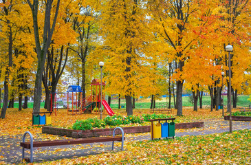 Playground in autumn park. Trees with colorful leaves
