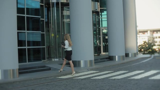 Young business woman is strolling in the city park business center