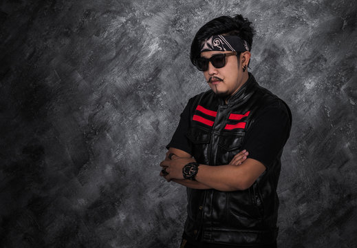 portrait of biker man in black leather jacket with arms crossed