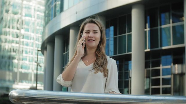 Young businesswoman talking is using smartphone in city park business center