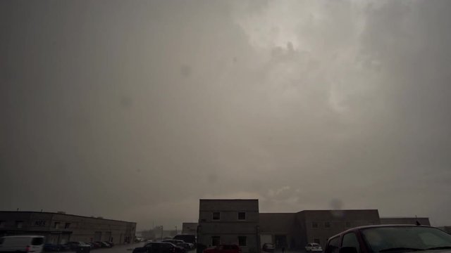 Time lapse of rain storm rolling through industrial area with dark gloomy clouds.