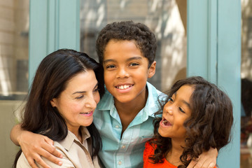 Happy Hispnaic mother laughing and talking with her children.