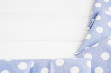 Light violet blue polka dots folded tablecloth over bleached wooden table. Top view image. Copyspace for your text.