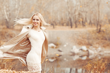 Fototapeta na wymiar stylish blond woman in the autumn park