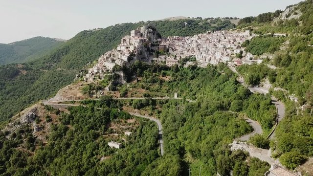 Aerial view of Cervara from far.
A small rural curch in foreground and the Ancient italian medieval village perched on a rock spur, with his ruined fortress at the top in far