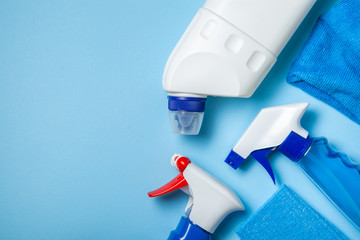 Cleaning supplies - bottles, sprays sponge on bright pastel background