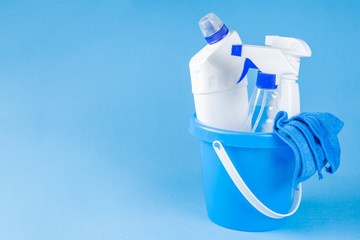 Cleaning supplies - bottles, sprays sponge on bright pastel background