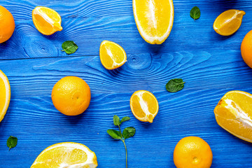 Cut oranges for juicy breakfast on blue background top view patt