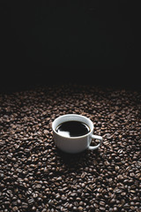 Black coffee in the cup And coffee beans background On the blackboard