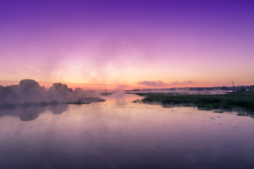 Magical purple sunrise over the river. Misty morning, rural landscape, countryside