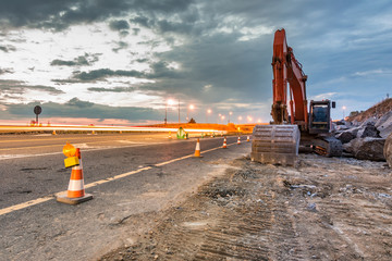 Works of extension of a road with excavator and delimited by safety cones