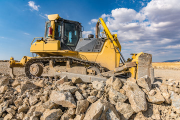 Obraz premium Excavator surrounded by granite rock to transform into gravel