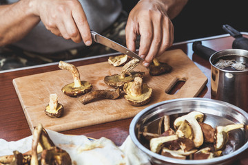 Hands cut raw mushrooms with sharp knife
