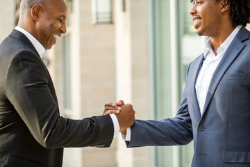 Mature African American casually dressed businessman shaking hands.