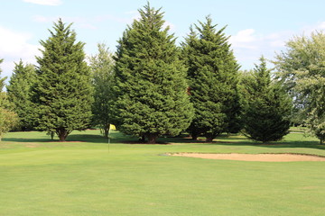 Fairway view of golf green with bunker to side