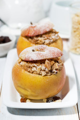 healthy breakfast. portioned oatmeal with raisins baked in apple, vertical