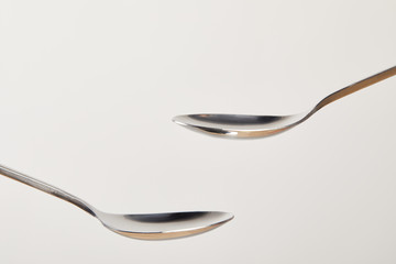 close up view of empty teaspoons on grey background