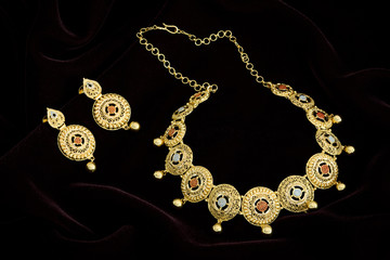 Modern golden necklace on a dark pattern
