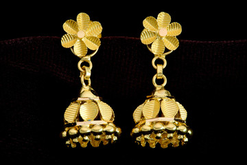 Golden earrings on a dark pattern