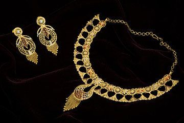 Golden paendant on a dark pattern