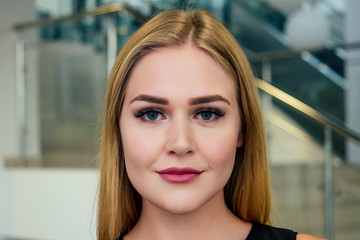 young and beautiful woman with artificial extended silk eyelashes eyes opened in a beauty studio, close up perfect skin