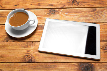 digital tablet and coffee cup on wooden table