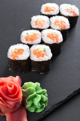 Japanese restaurant, sushi roll on black slate plate.