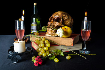 Naturaleza muerta con una calavera con rosas, libros, frutas, vino y velas sobre un fondo oscuro	