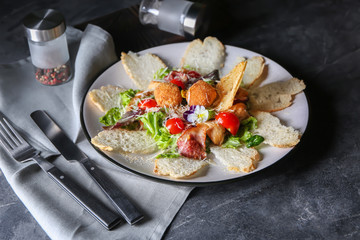 Plate with delicious fresh salad and bread on grey table