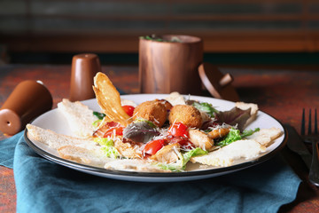 Plate with delicious fresh salad and bread on color table