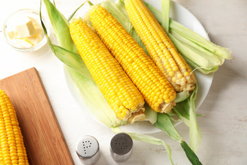 Composition with tasty corn cobs on wooden table