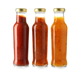 Bottles with tasty sauces on white background