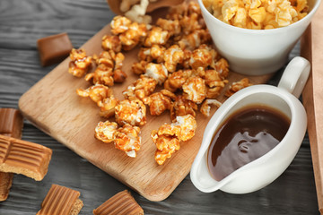 Delicious caramel popcorn on wooden background, closeup