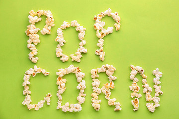 Words made of delicious popcorn on color background