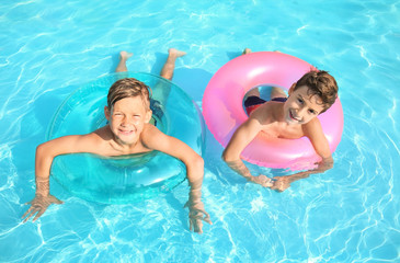 Cute boys swimming in pool on summer day