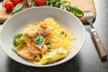 Plate of delicious pasta with chicken fillet and cheese on table, closeup