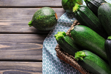 Basket with ripe zucchinis on wooden table
