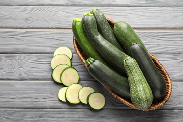 Basket with ripe zucchinis on wooden table