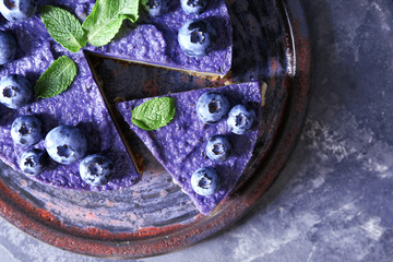 Plate with tasty blueberry cheesecake on dark table, closeup