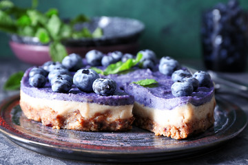Plate with tasty blueberry cheesecake on table, closeup